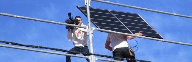 installateurs de PV et cameraman sur le toit 